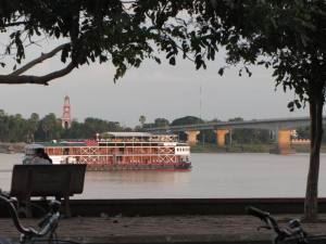 Houseboat approaching the Kizuna Bridge, with the old French Tower across the shore from Kampong Cham