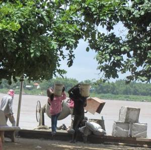 Men and women carry heavy loads on their shoulders all day for $4 per day