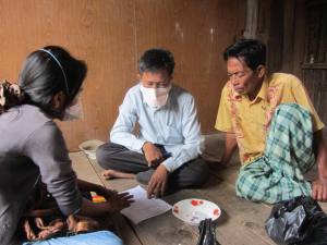 Direct Observed Treatment in a patient's home: MSF Nurse, Village Health Volunteer and a family member discuss the medications
