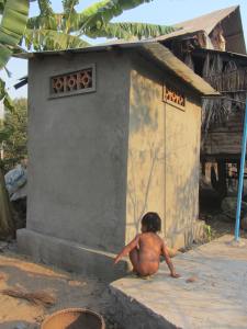 Shining wet 2yo perched on the covered, ventilated septic tank next to the new toilet
