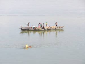 Children swim ashore using a polystyrene box to stay afloat